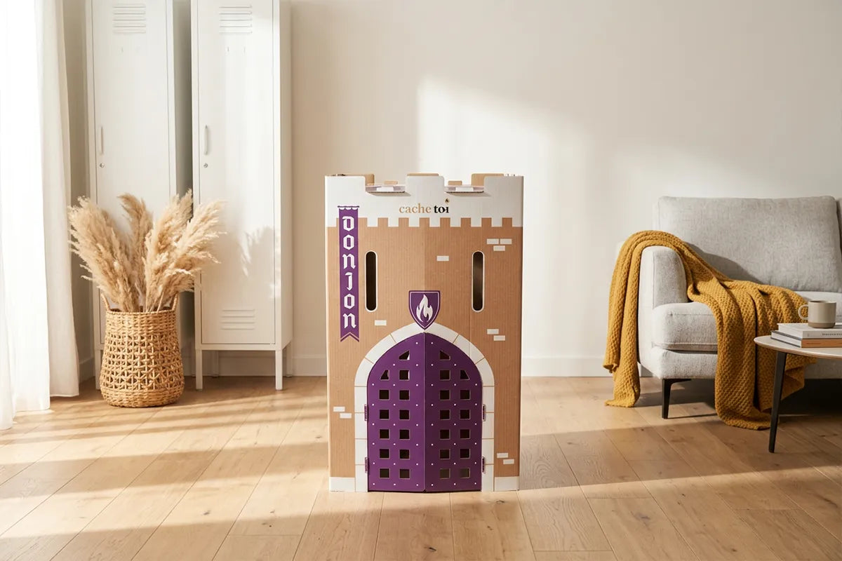 La cabane en carton pliable Donjon de la marque cache-toi, installée au centre d'un salon moderne et lumineux avec une décoration scandinave.