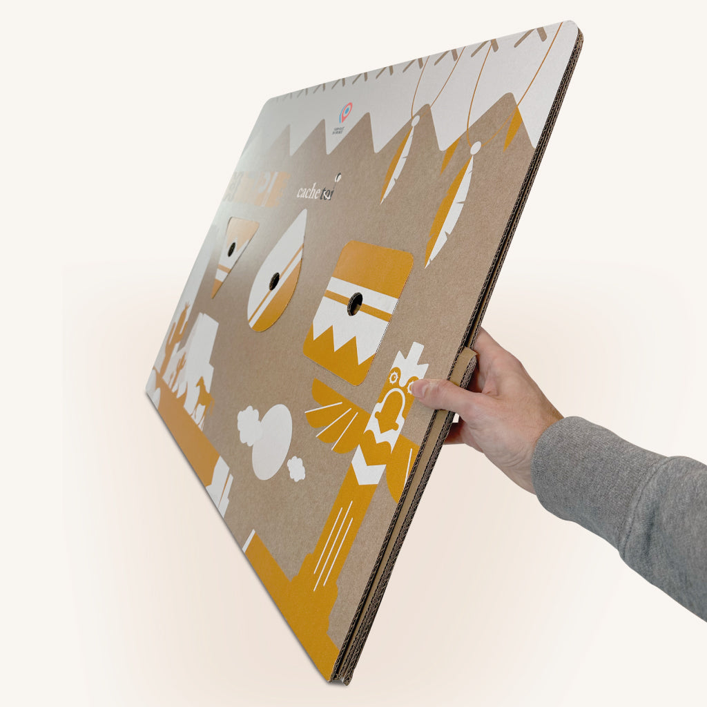 Tipi en carton cache-toi entièrement replié et tenu d'une seule main pour montrer son format extra-plat.