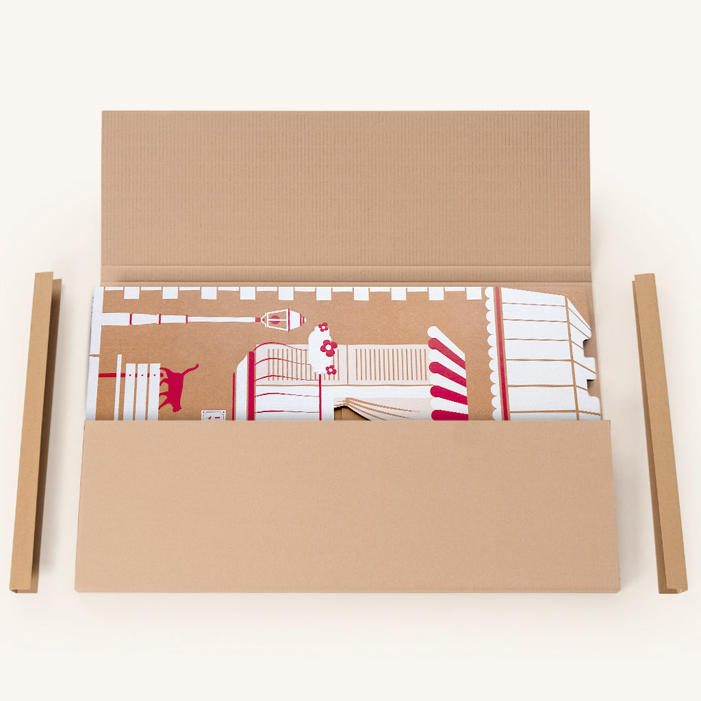 Maisonnette en carton pliable Home cache-toi repliée à plat et rangée dans son emballage carton compact ouvert.