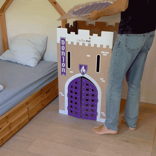 Rangement de la cabane en carton pliable cache-toi modèle Donjon sous un lit d'enfant